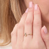 Gold ring on a person's finger with a blurred background