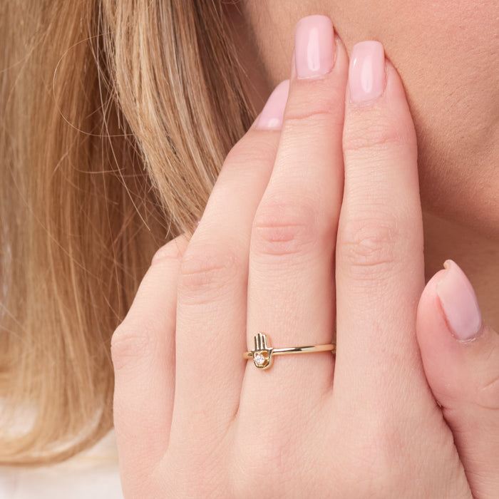 Gold ring on a person's finger with a blurred background