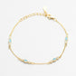 Gold bracelet with blue gemstones on a white background