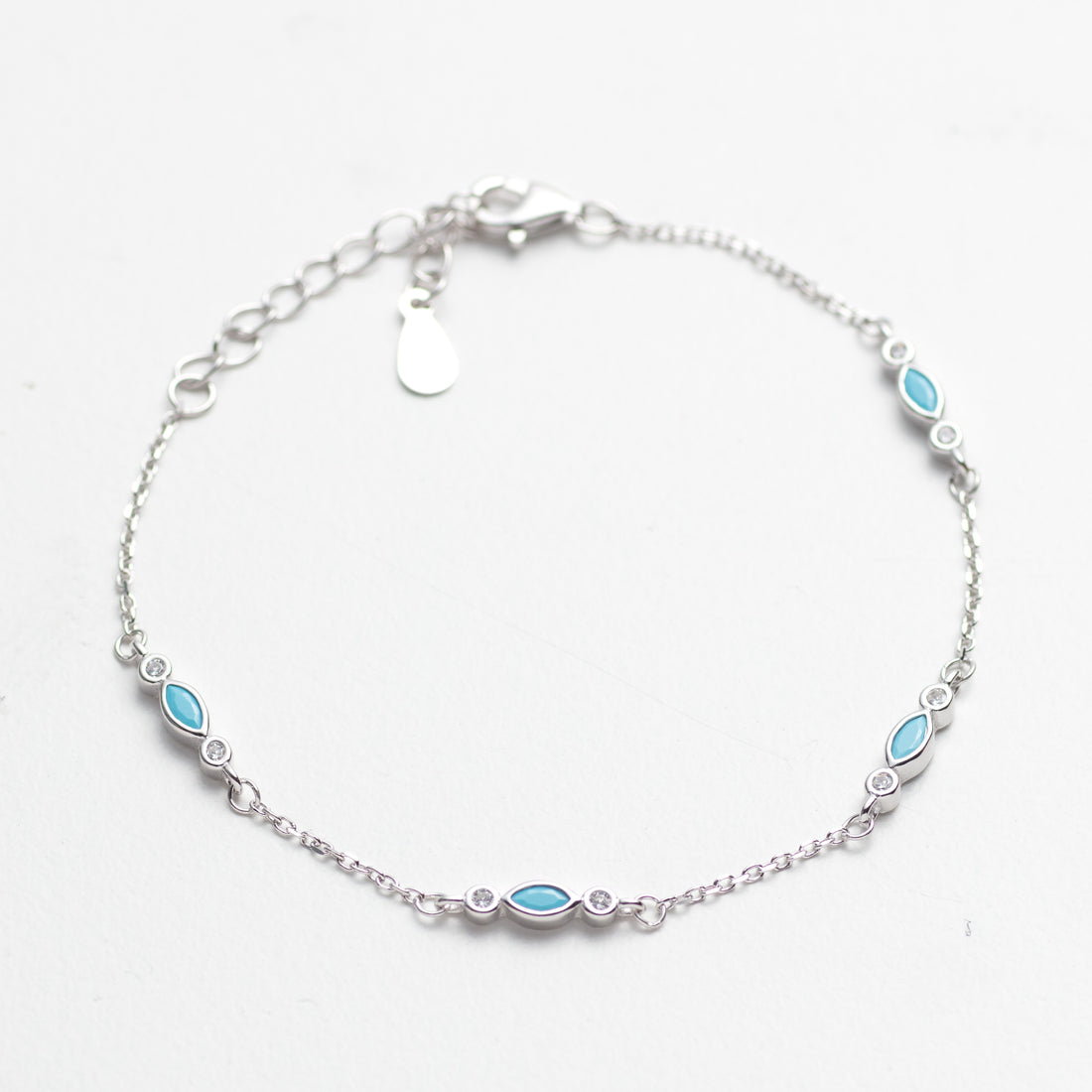 Silver bracelet with blue gemstones on a white background