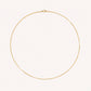 Gold necklace on a light pink background