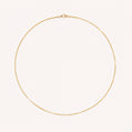 Gold necklace on a light pink background