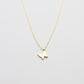Gold butterfly necklace on a light gray background