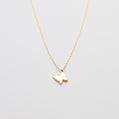 Gold butterfly necklace on a light gray background