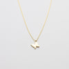 Gold butterfly necklace on a light gray background