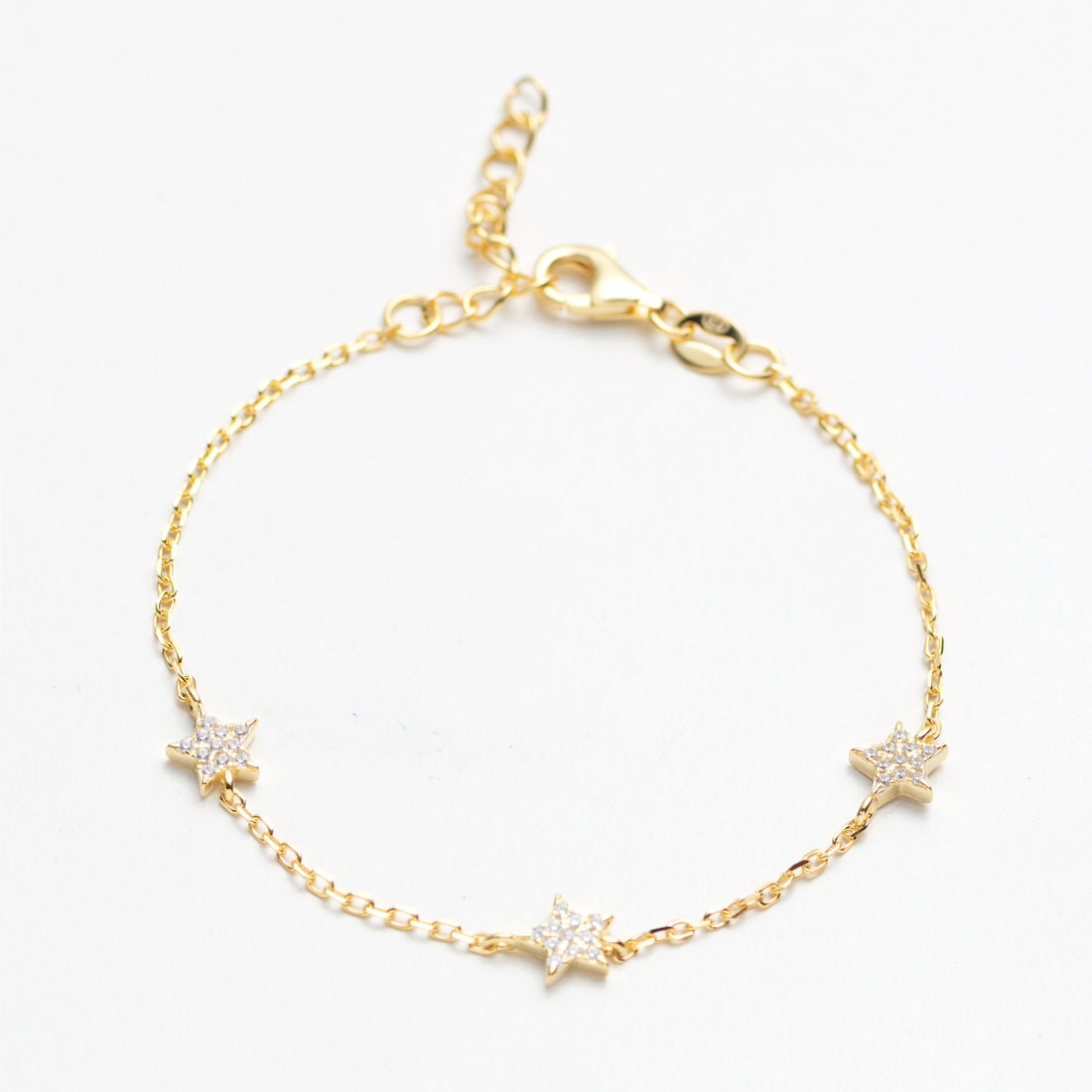 Gold bracelet with star-shaped charms on a white background