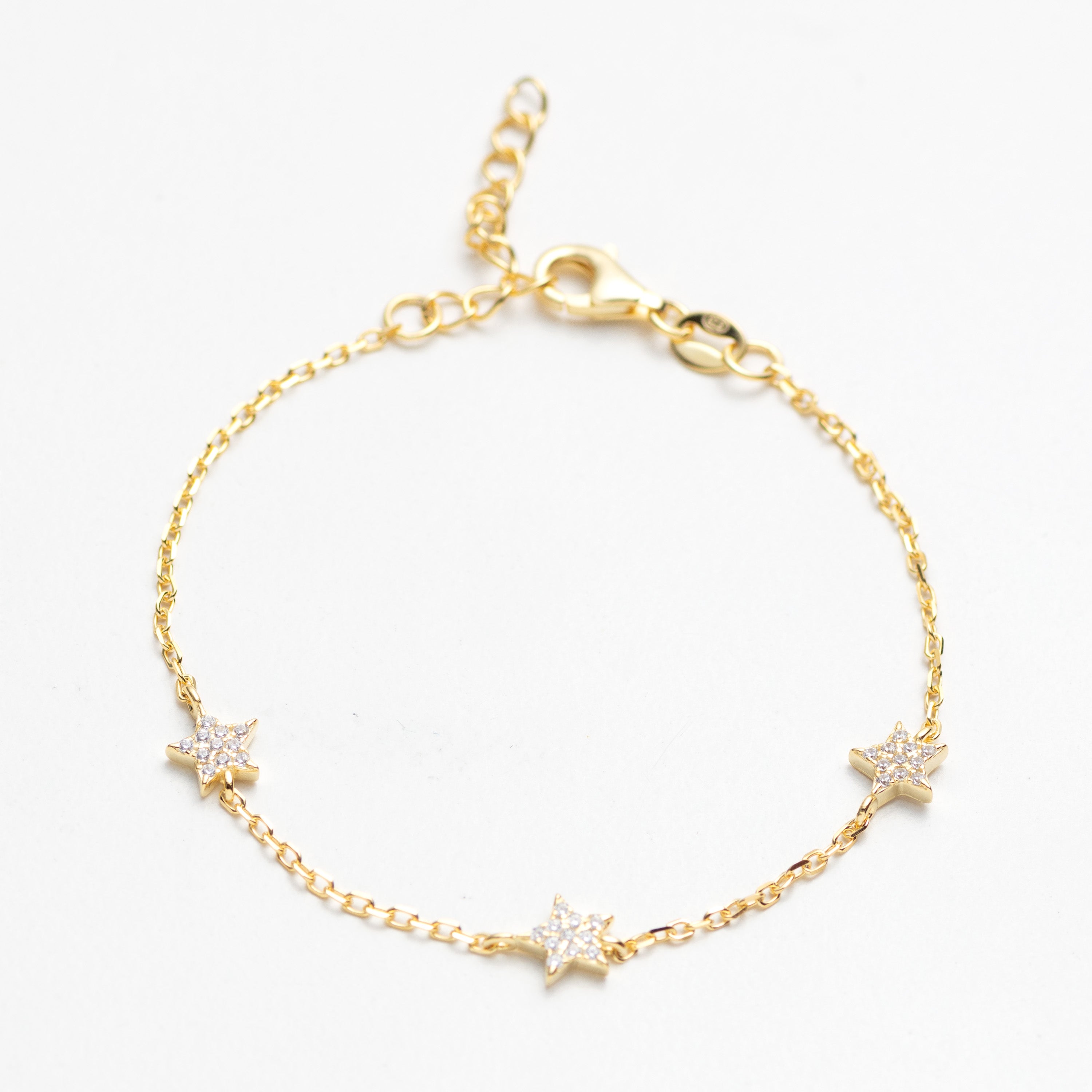 Gold bracelet with star-shaped charms on a white background