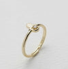 Gold ring with a diamond on a light gray background
