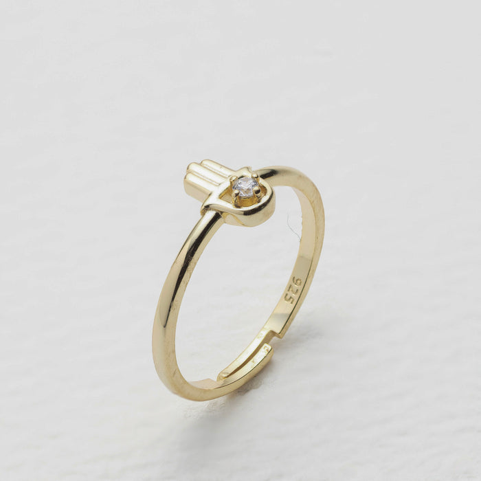 Gold ring with a diamond on a light gray background