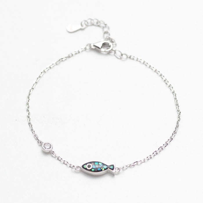 Silver bracelet with a fish-shaped charm on a white background