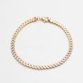 Gold bracelet with clear stones on a white background