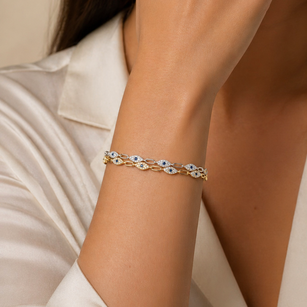 Gold bracelet with blue stones on a person's wrist against a neutral background