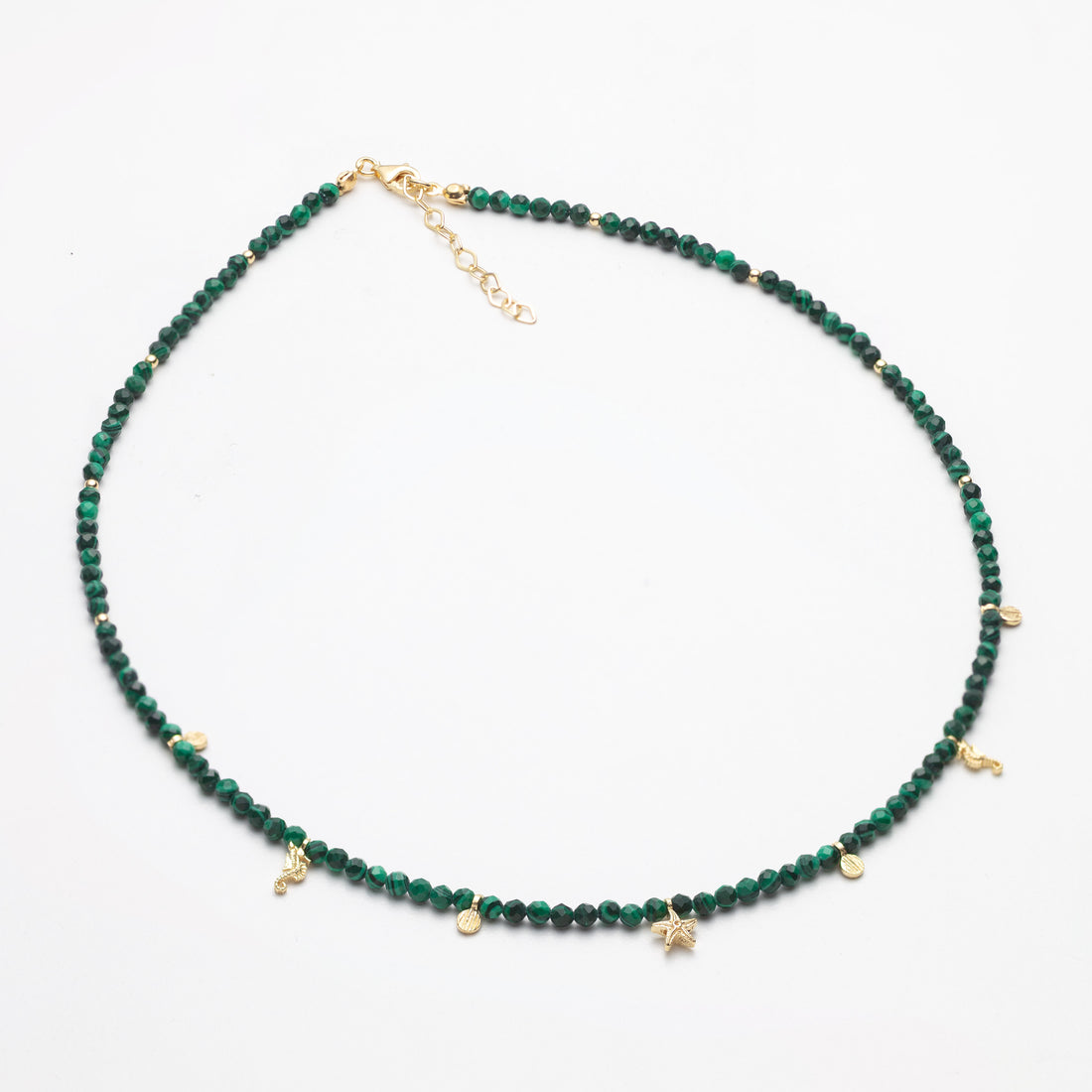 Green beaded necklace with gold accents on a white background