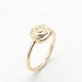 Gold rose-shaped ring on a white background