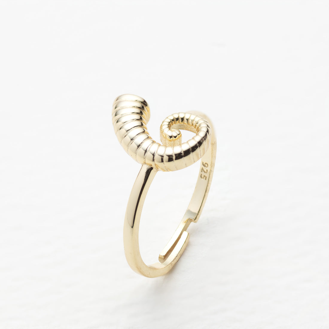 Gold ring with a unique design on a white background