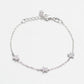 Silver bracelet with star-shaped charms on a light gray background