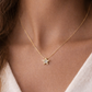 Gold necklace with a star pendant worn by a person