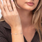 Woman wearing a silver bracelet and ring on a neutral background
