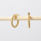 Gold hoop earrings on a light gray background
