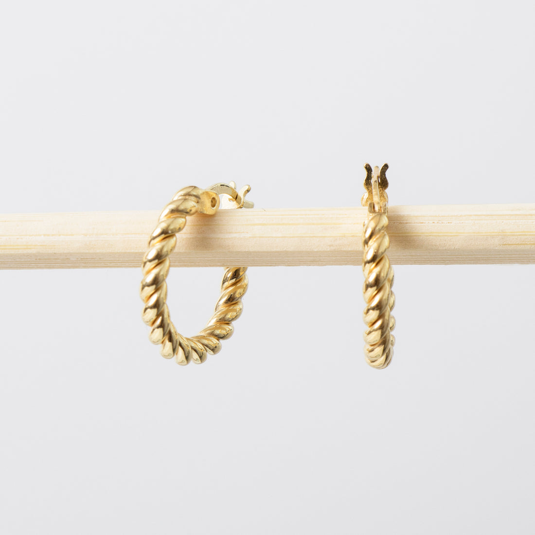 Gold hoop earrings on a light gray background
