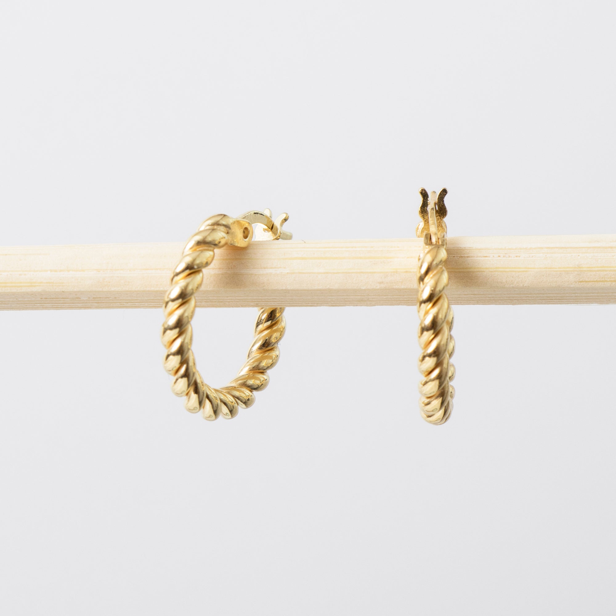 Gold hoop earrings on a light gray background