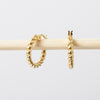 Gold hoop earrings on a light gray background